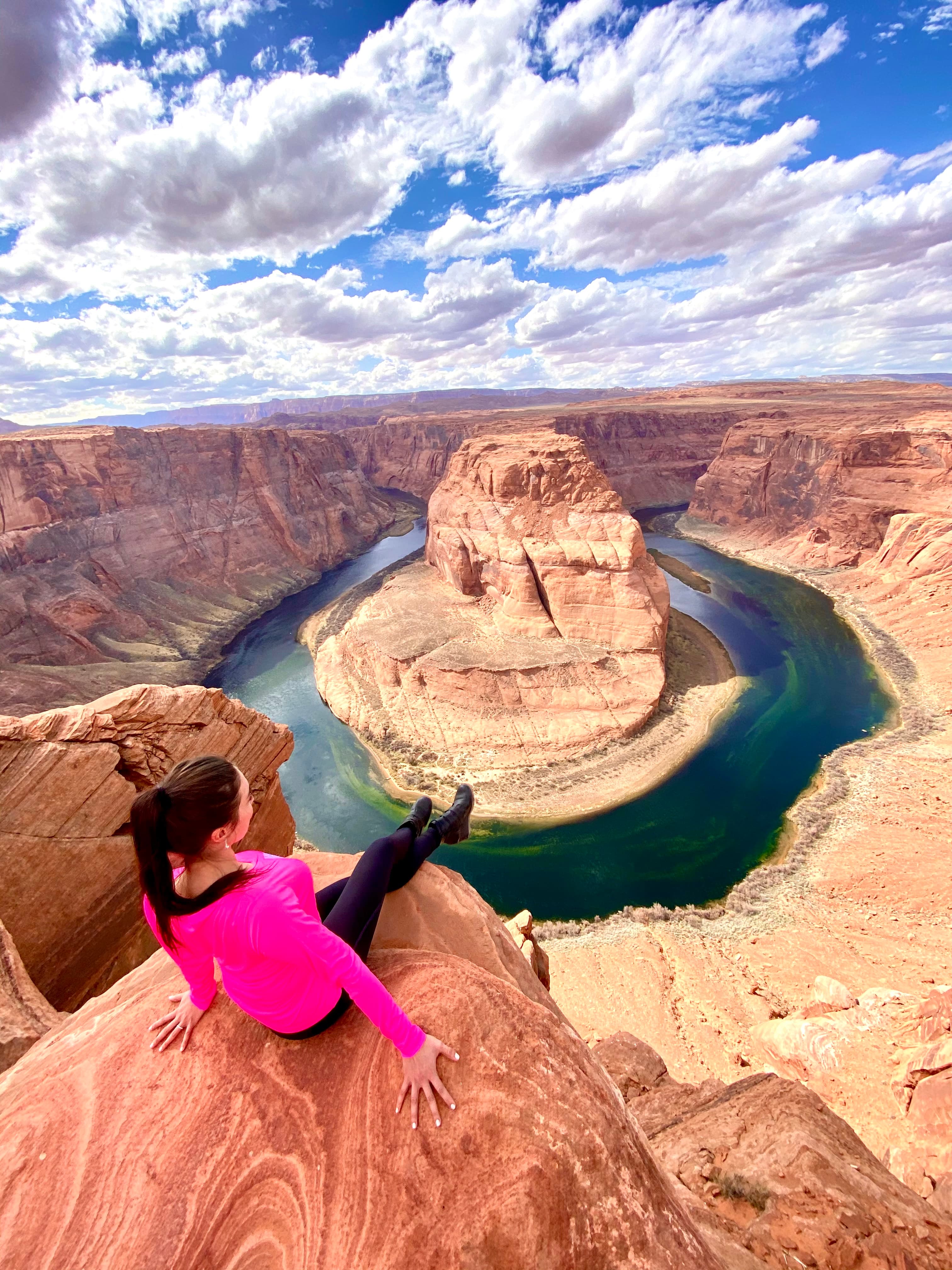 Travel Advisor on a desert hike sitting in a high mountain range with a beautiful view.