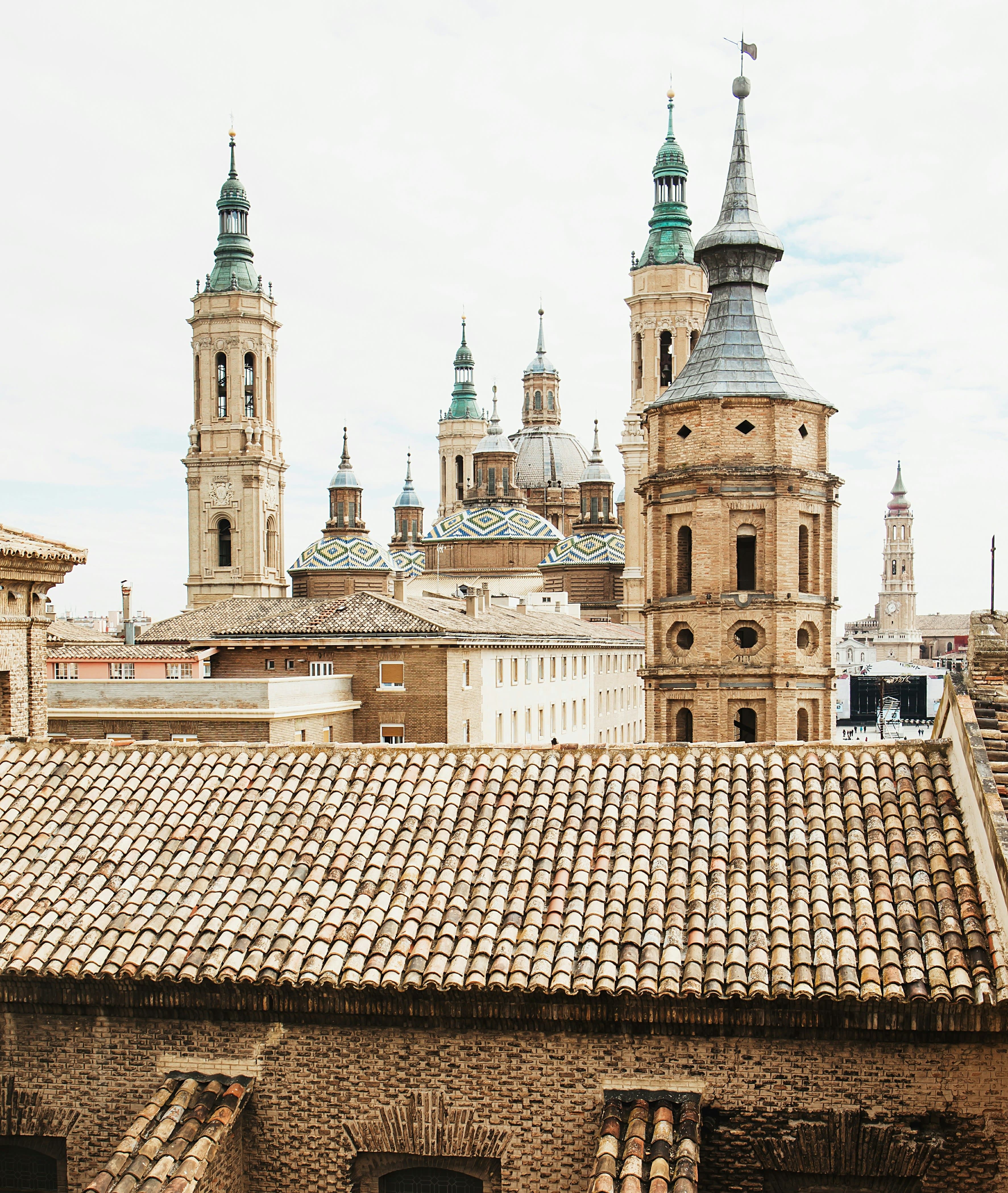 Colorful houses and apartment buildings in rows, above a stone wall in Spain.