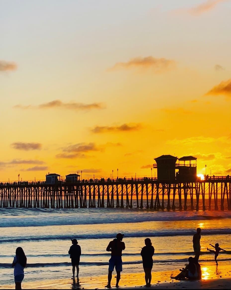 ocean in San Diego during sunset with a pier and people enjoying the view.