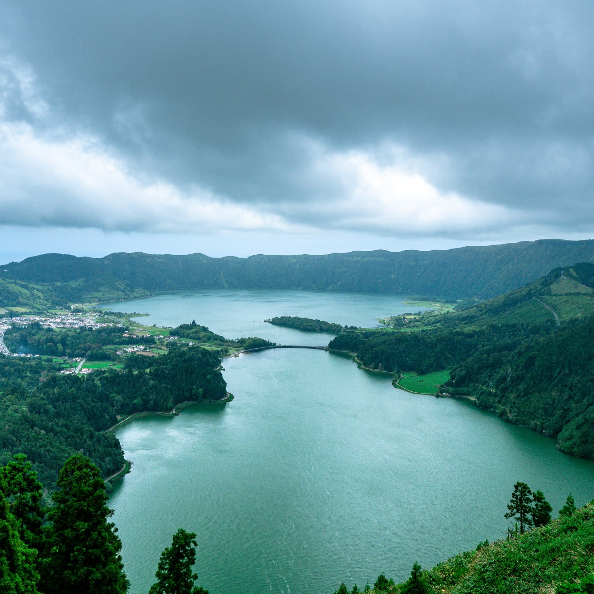 Aerial view of water body surrounded by green hills.