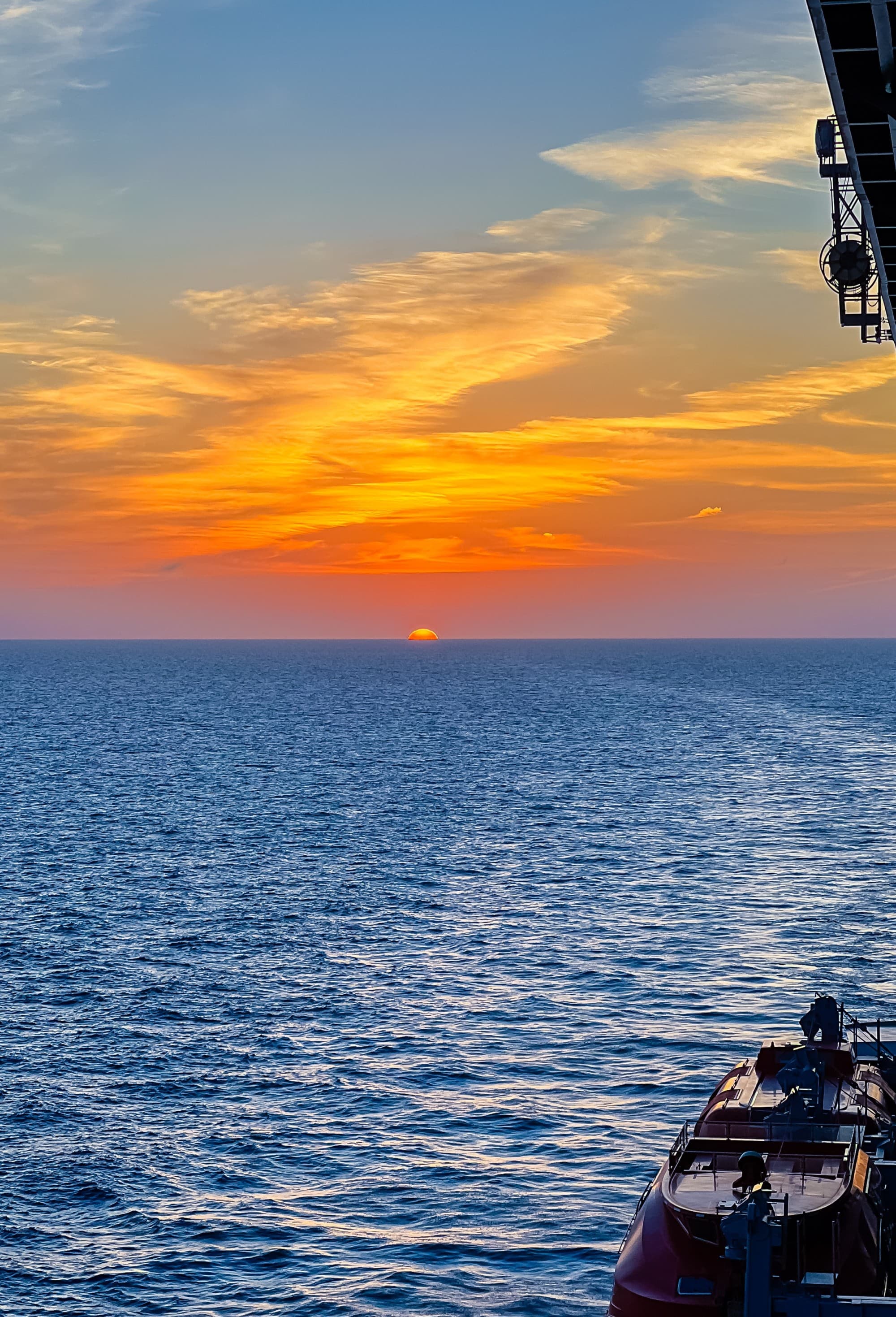 View of the ocean and skyline from a cruise ship at sunset