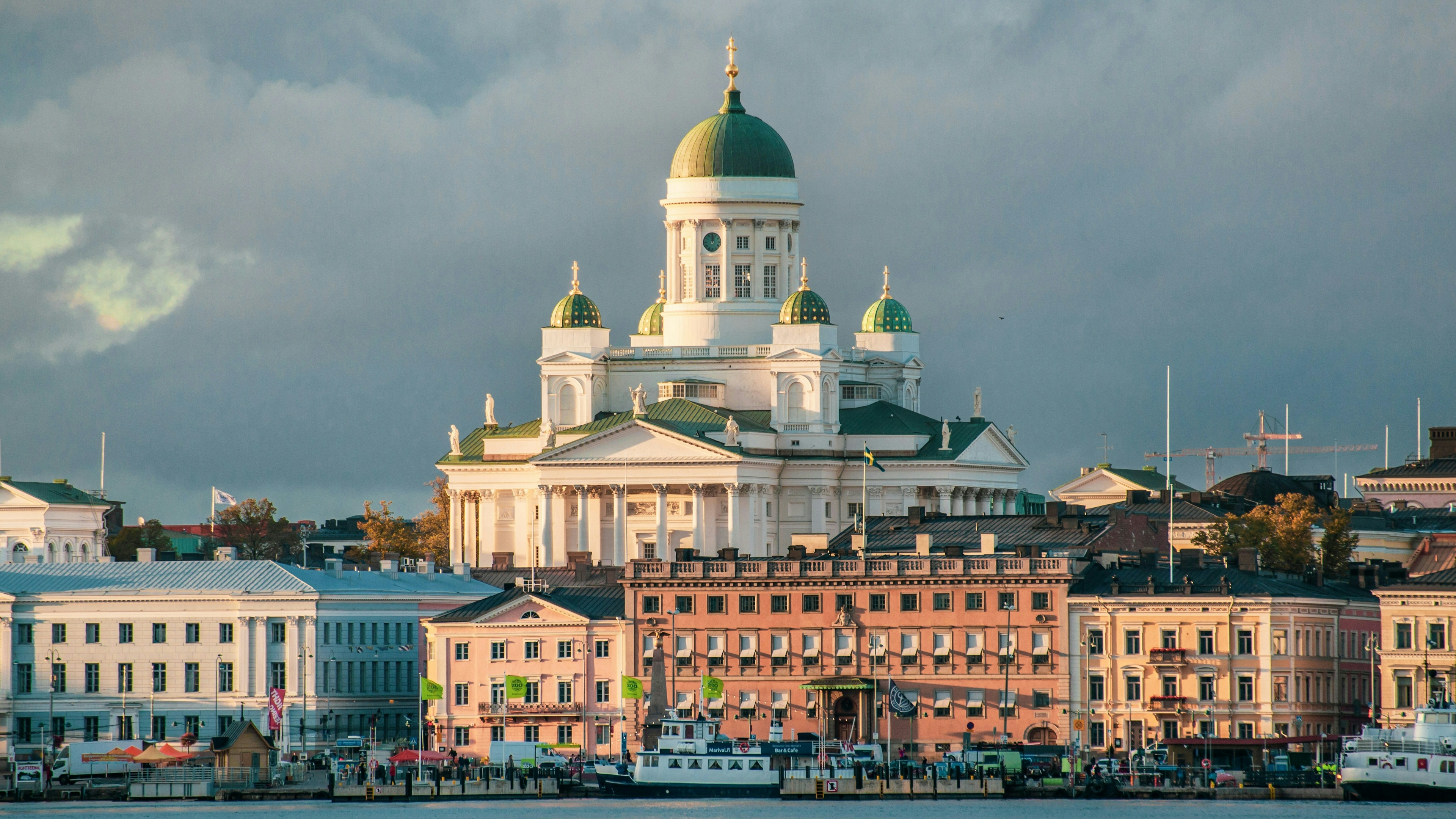 The Helsinki Cathedral and city buildings along the gulf in autumn sunset.