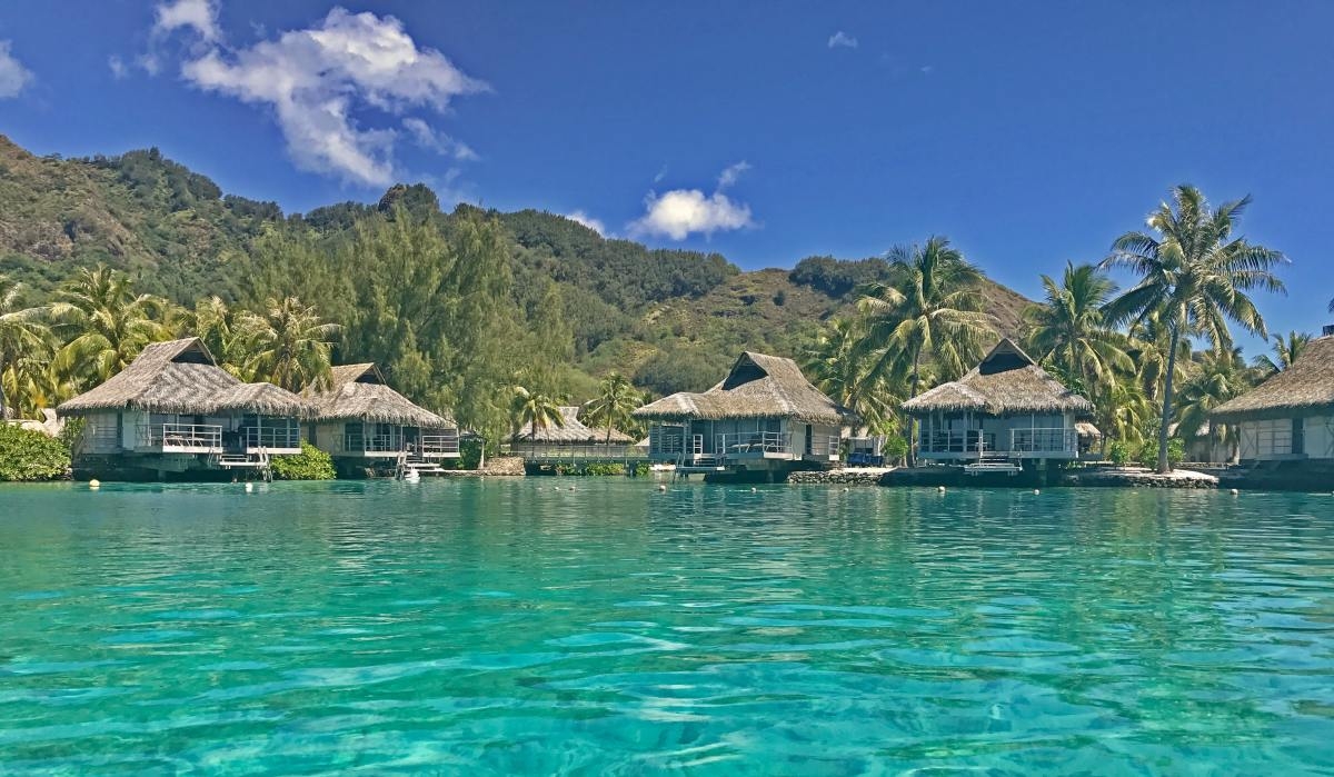 Thatched huts perched above a turquoise sea in French Polynesia
