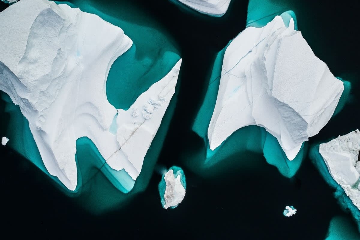 Aerial view of multiple icebergs in the water. 