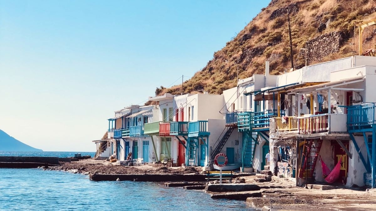 Boats on the sea near houses during daytime