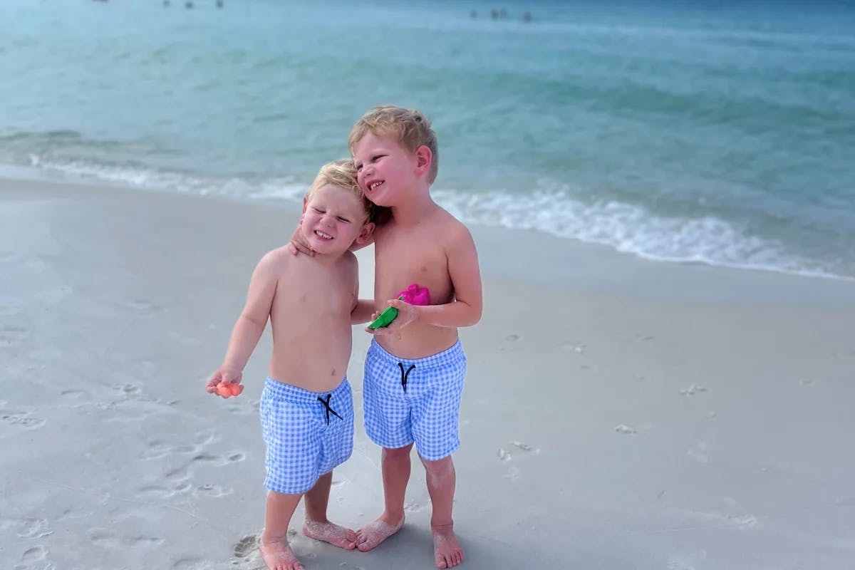 A picture of two kids on a beach during daytime.