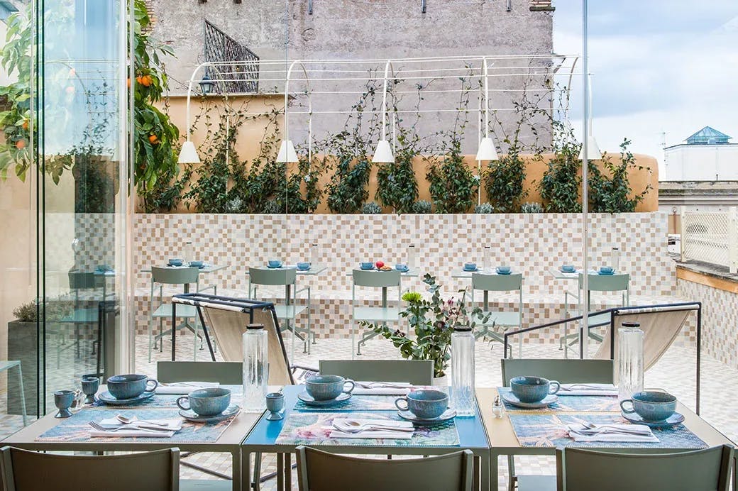 a rooftop terrace with blue tables and chairs