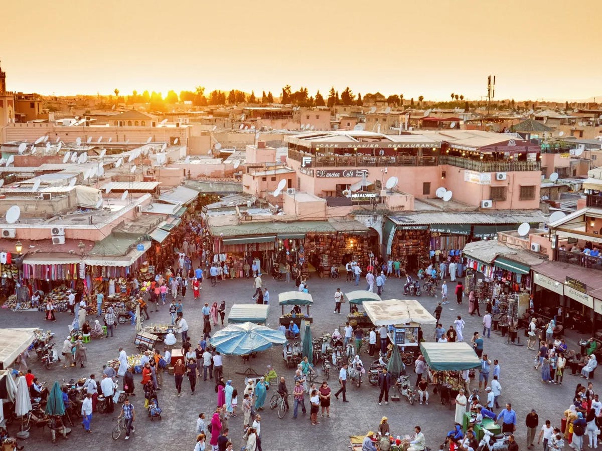 A sunset market square bustling with people and activity.