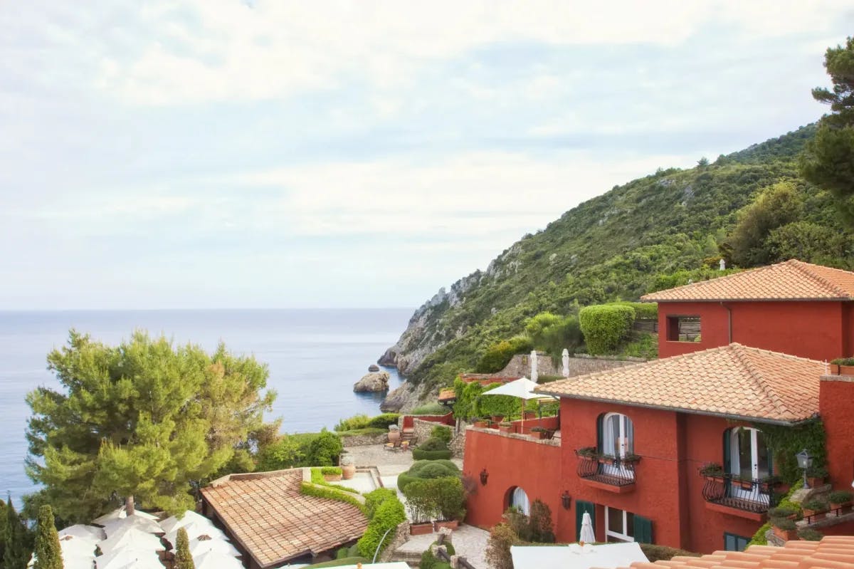 a red Italian villa on a lush seaside hill