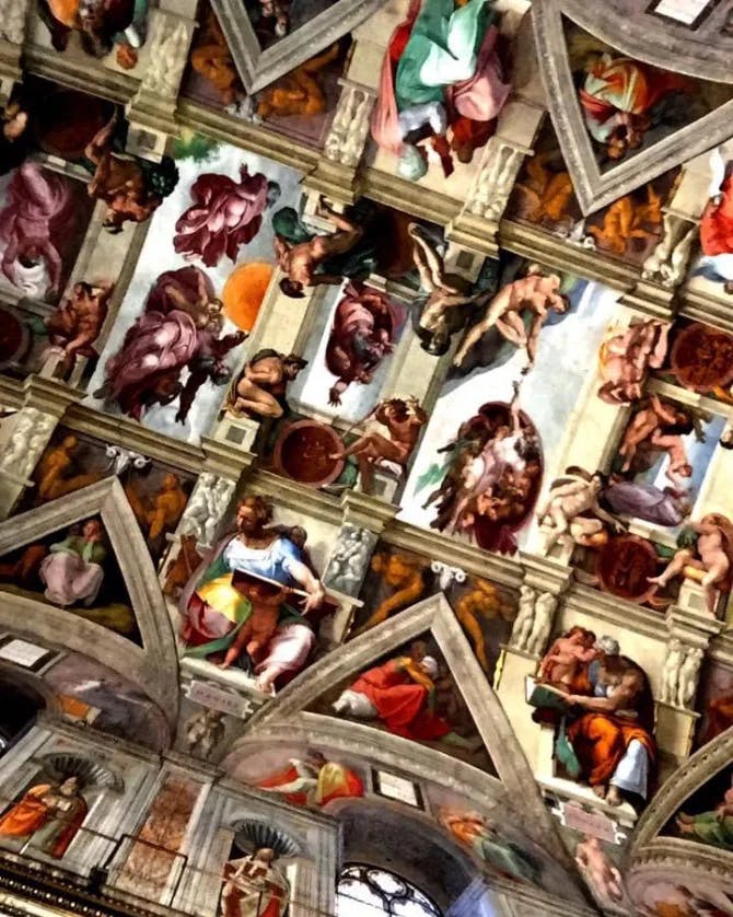 View of an ornately decorated church ceiling with figures of angels and saints