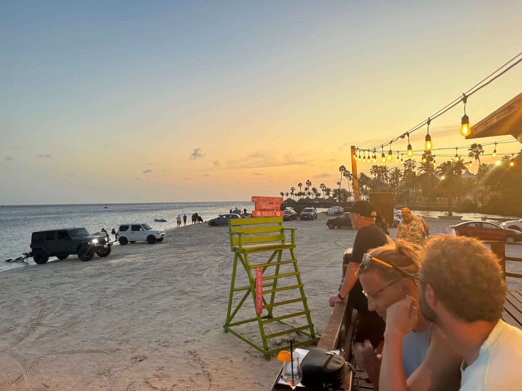 People sitting on a beach during the sunset