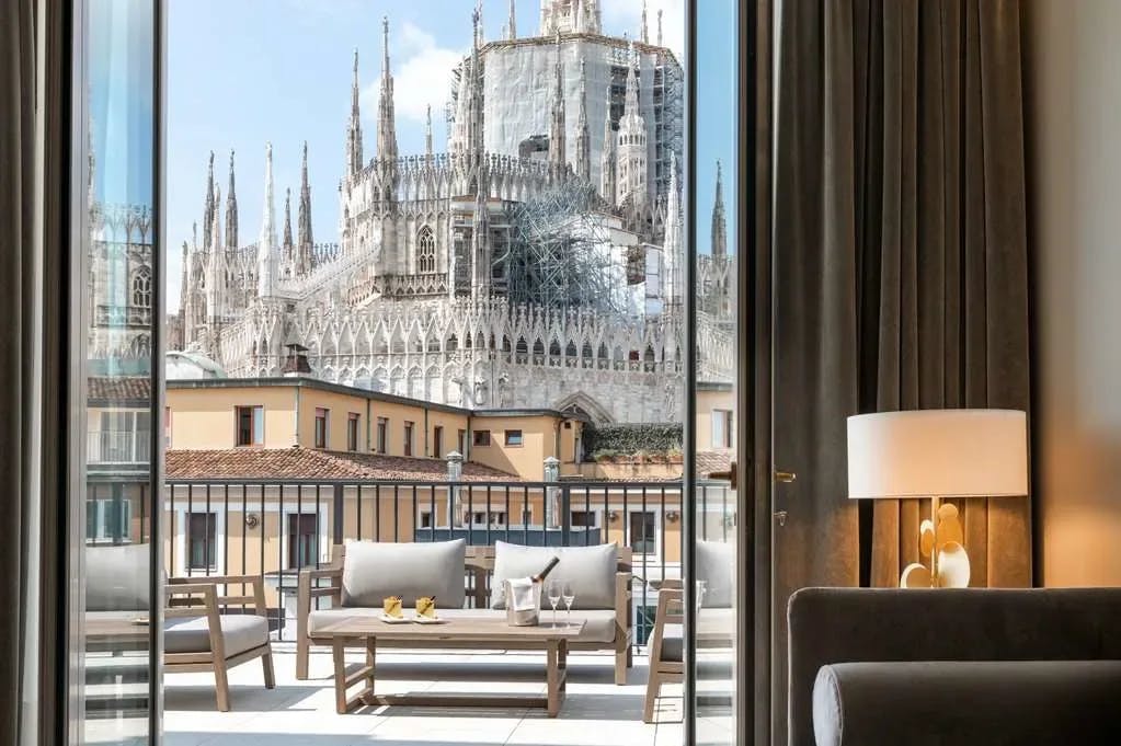 Beyond a chic patio with lounge seating: scaffolding surrounds a gorgeous historic building in Milan