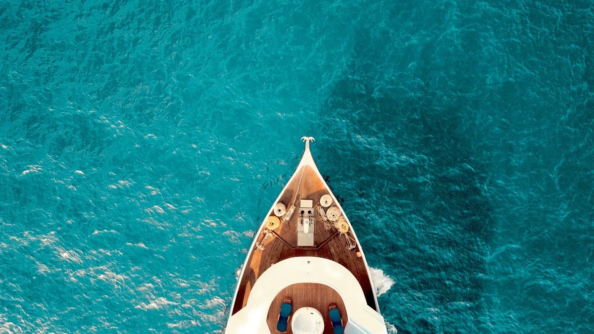 A bird eye picture of a yacht on the water taken during daytime.