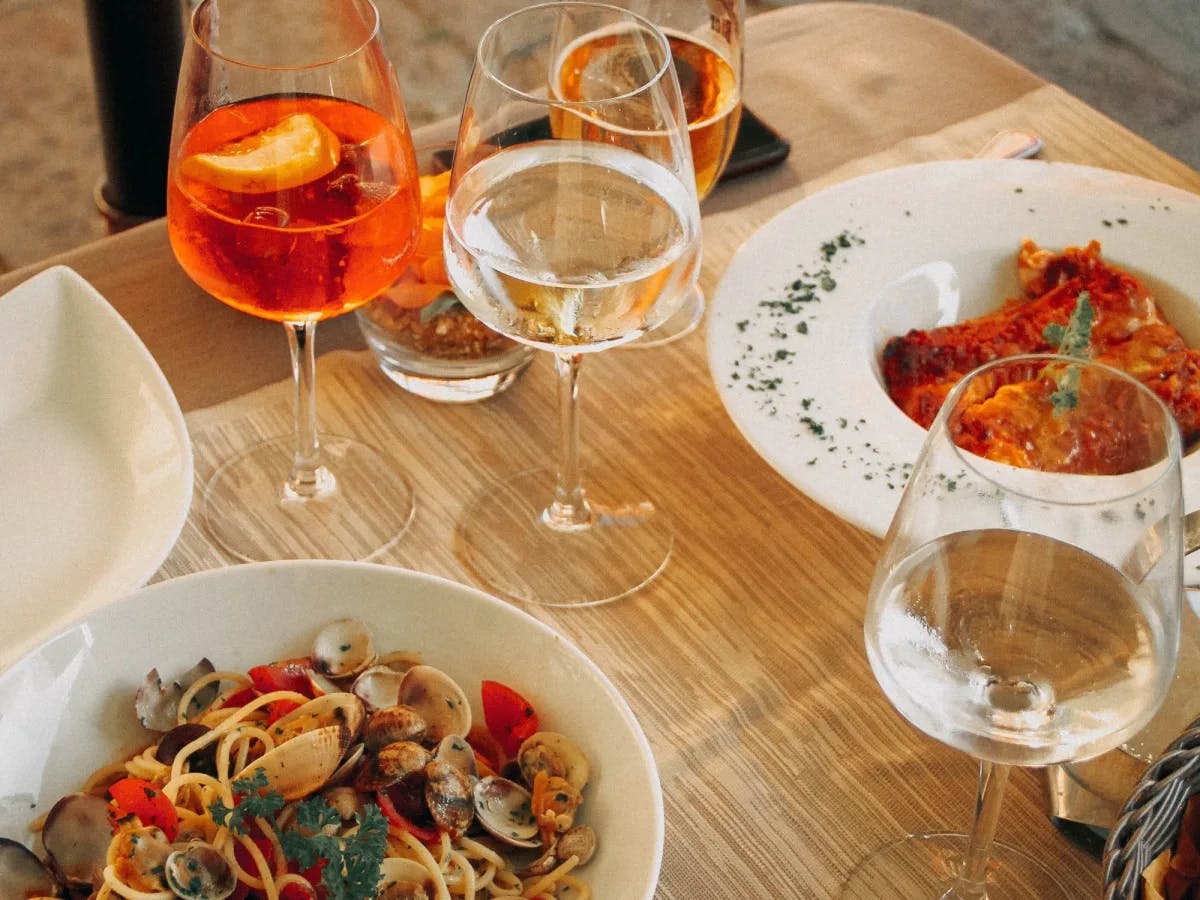 A table with pasta and wine glasses. 