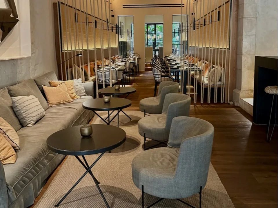 An indoor sitting area with grey chairs and sofas.