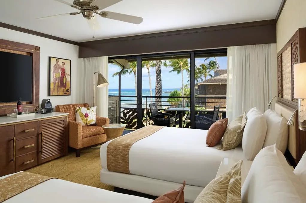 A modern hotel room featuring two queen beds with a coastal style at a resort with oceanfront views.