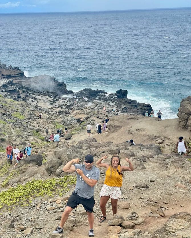 Shana poses on the rocky steep shores of island with a man