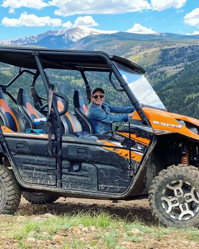 Travel advisor driving a four wheeler in the mountains.