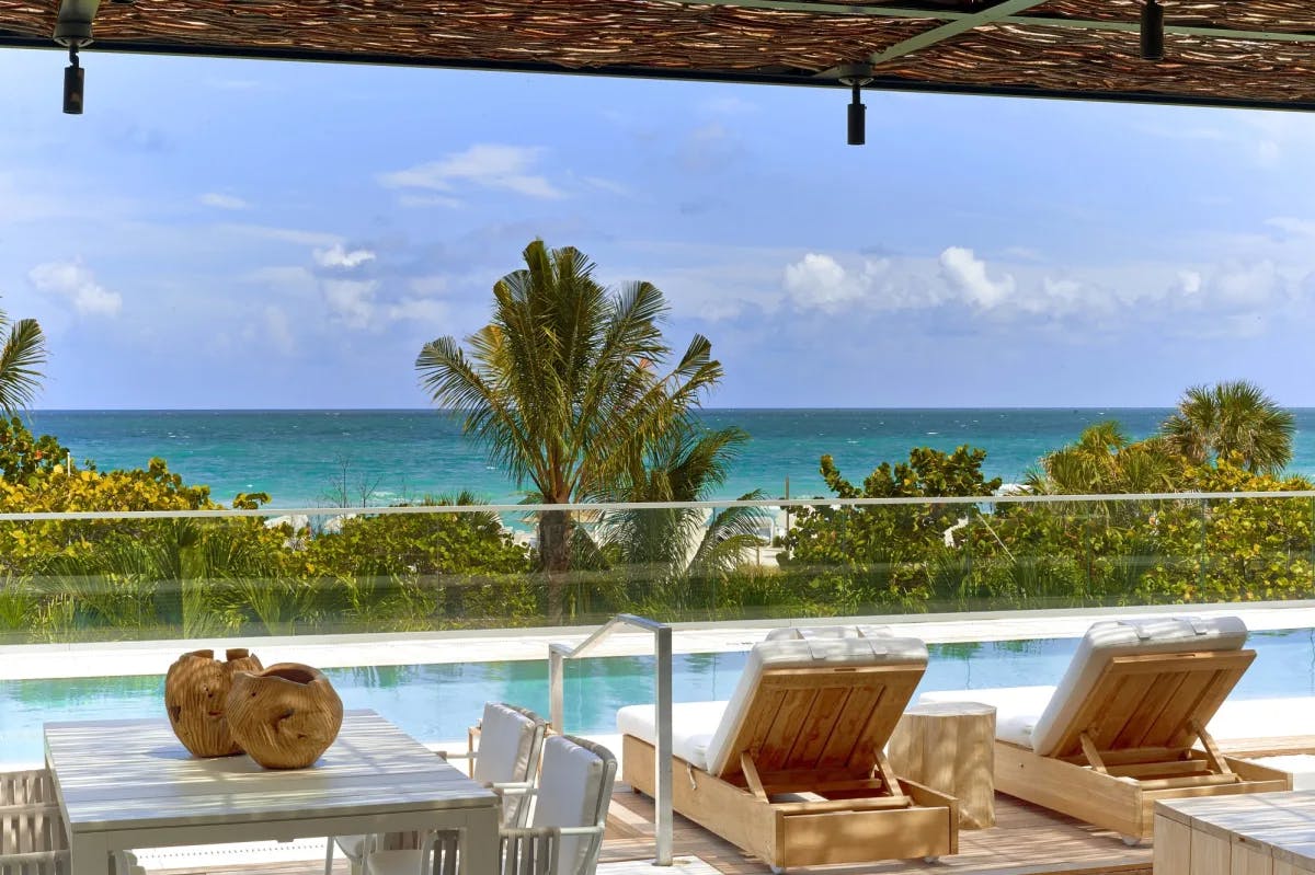 plush white loungers on a poolside deck overlooking the ocean