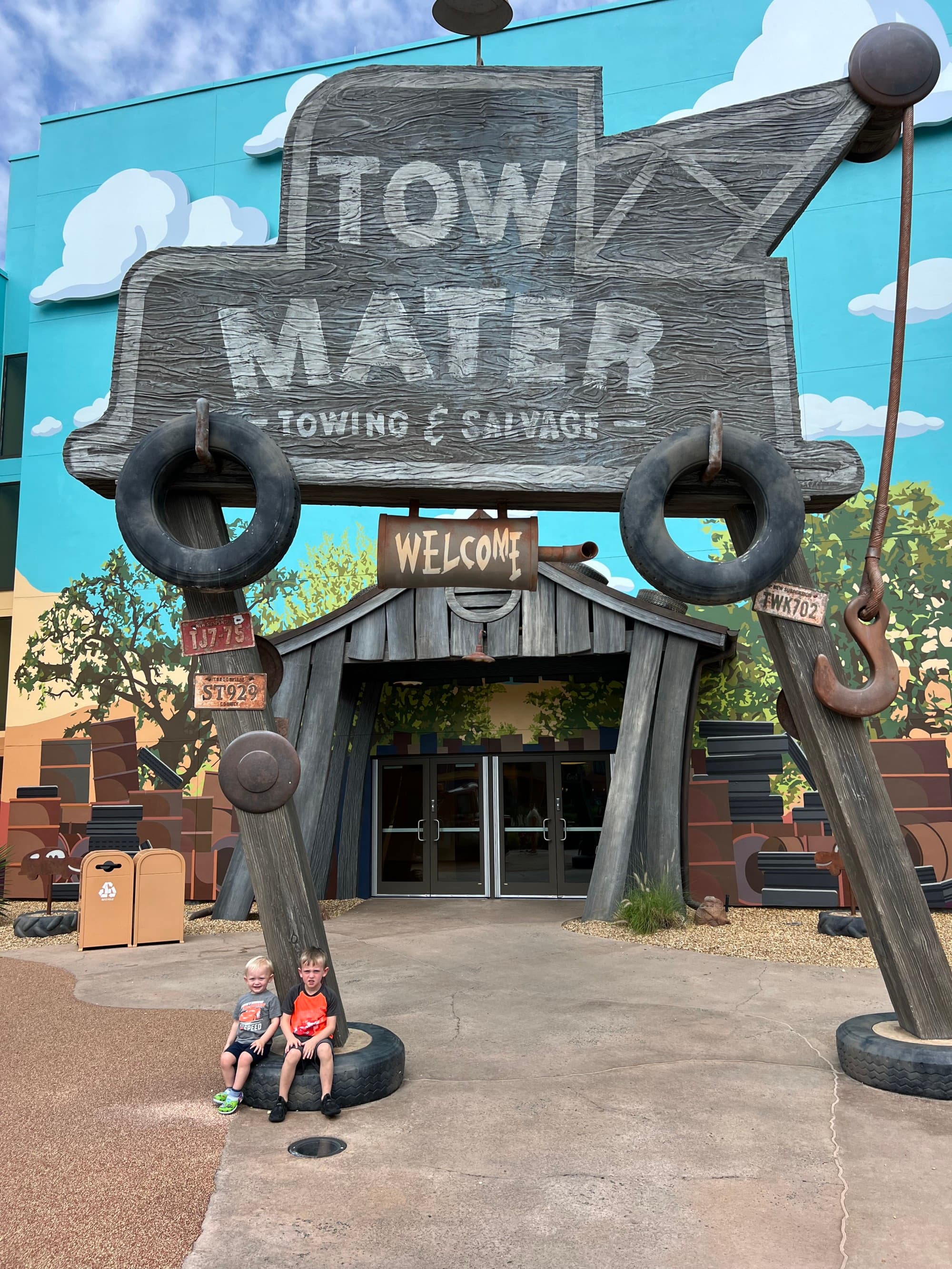 Children sitting in front of a park sign 