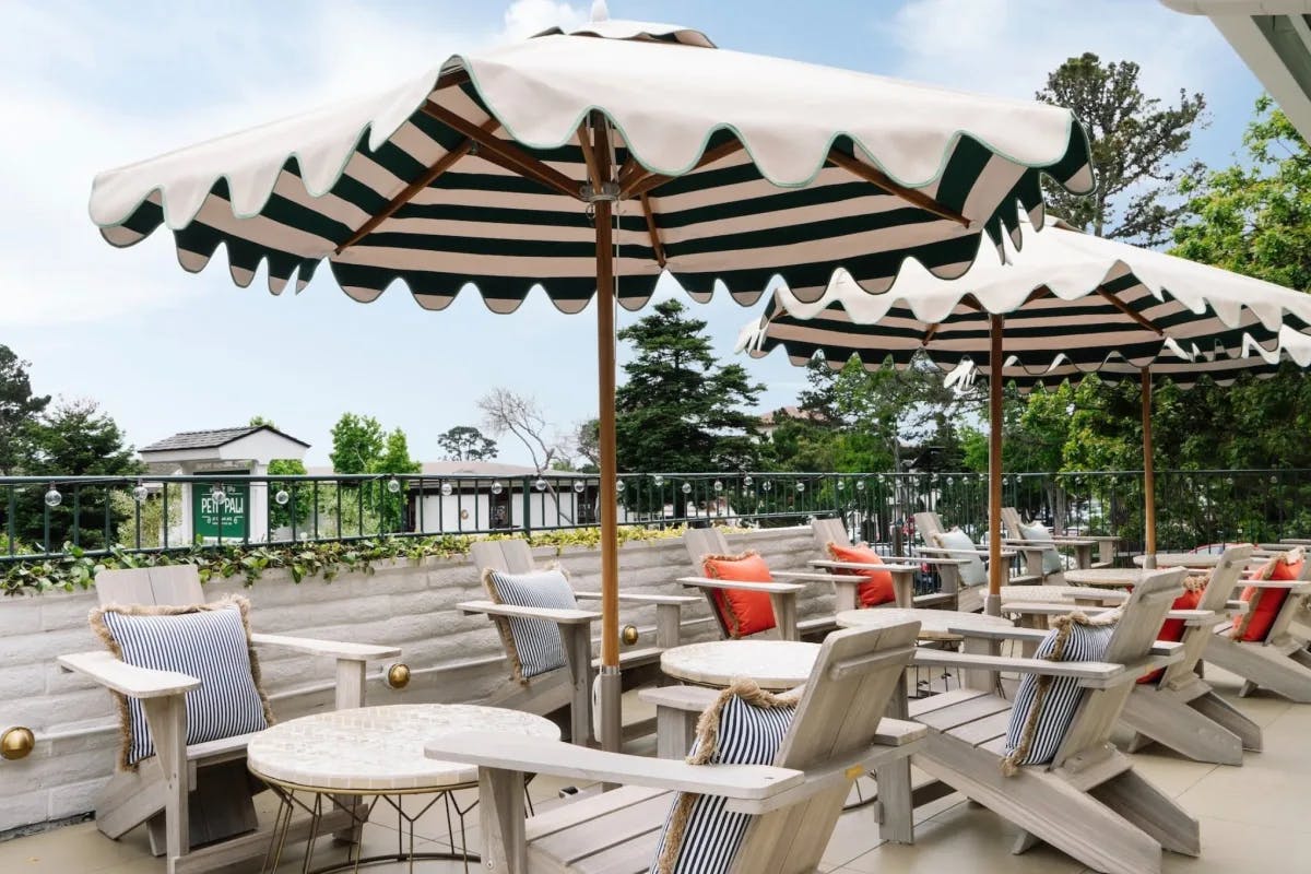 terrace with striped umbrellas and adirondack chairs surrounded by trees