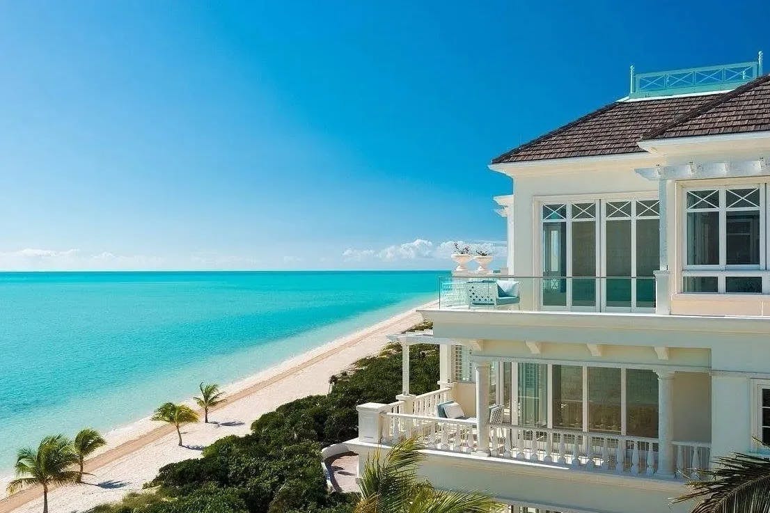 cream colored hotel exterior with view of beach and turquoise sea