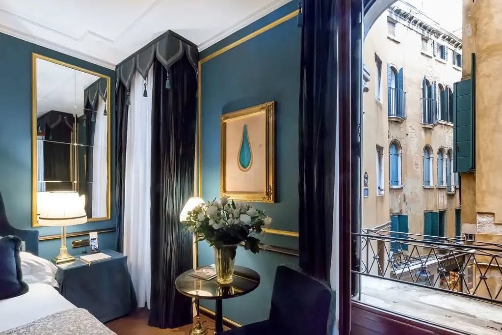 a hotel room with blue walls and a bouquet of flowers in a metal table