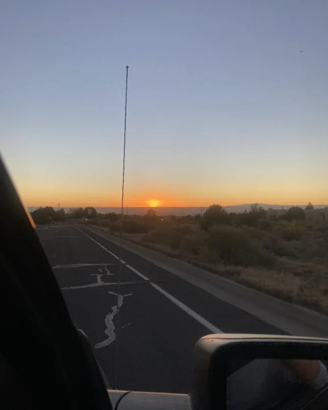 Driving down the road in a car into the sunset