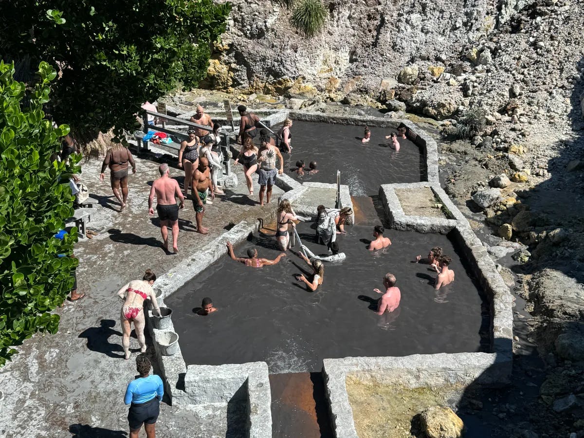 A group of people stands on a rocky outcrop, with some individuals blurred for privacy.