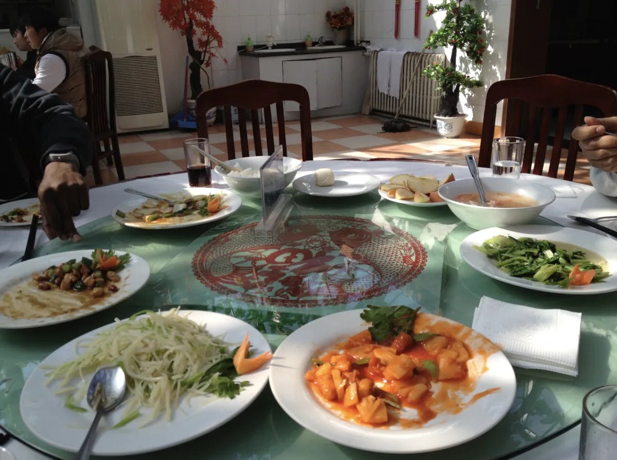 Multiple plates of food laid out on a round table