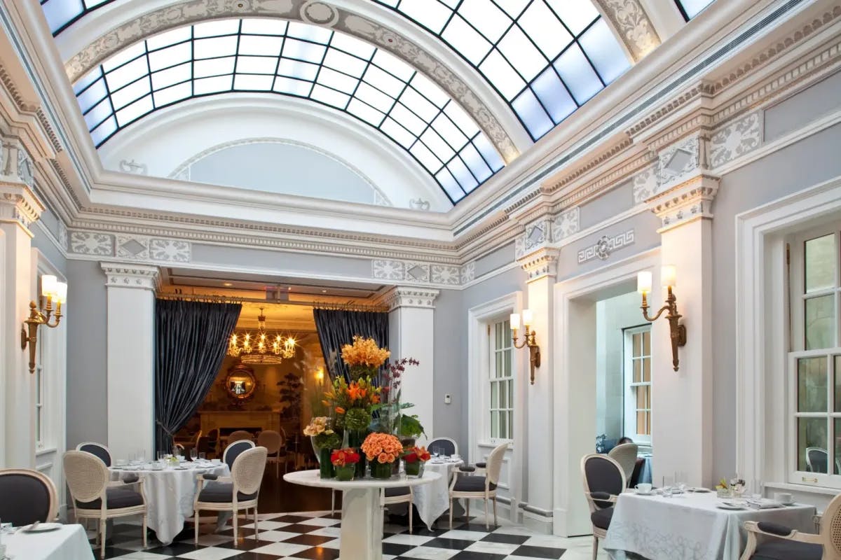 an airy dining room with black-and-white tiled flooring