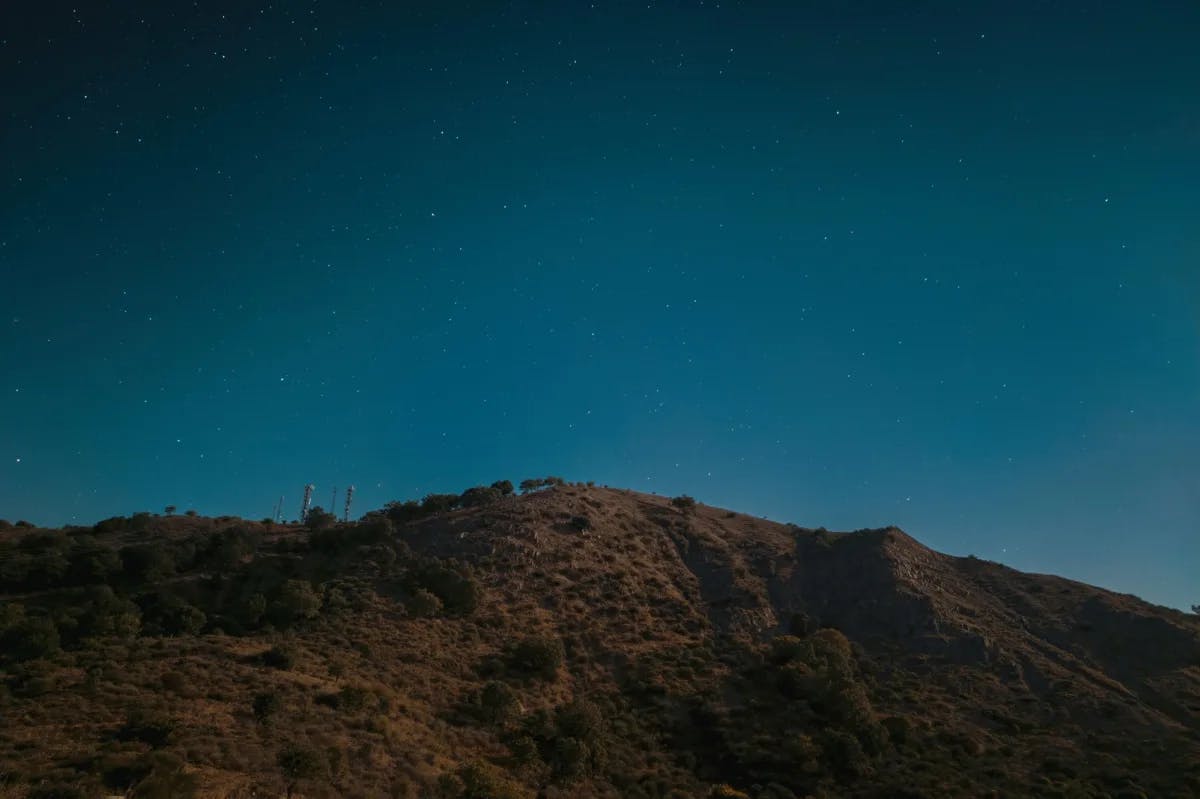 Mountain under starry sky.