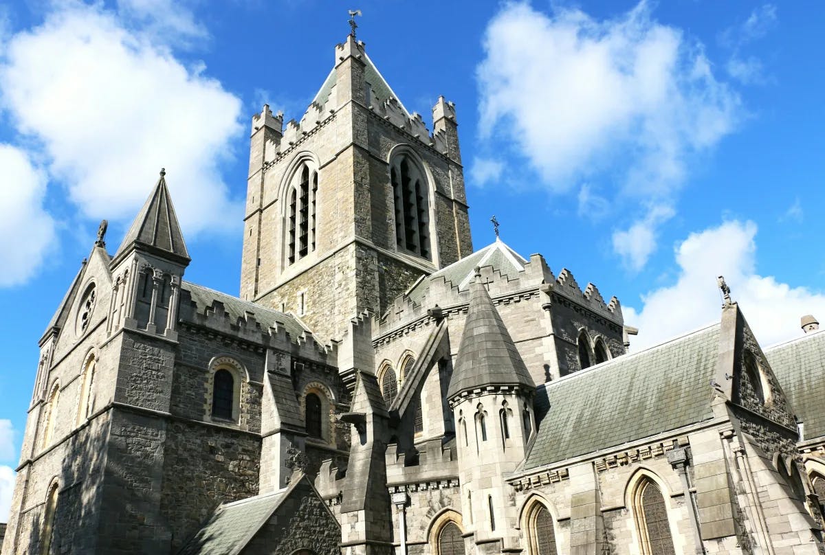 A view of Christ Church Cathedral, one of the medieval cathedrals in Dublin with a partly cloudy sky during the day.