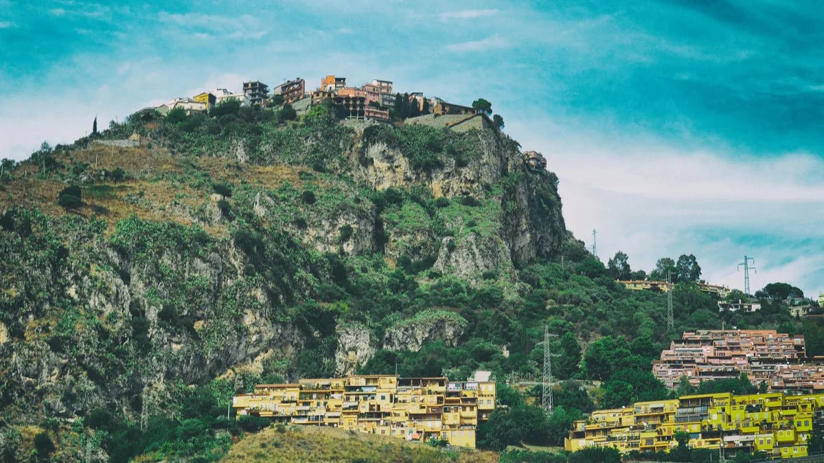 Landscape photo of concrete structures atop a large hill