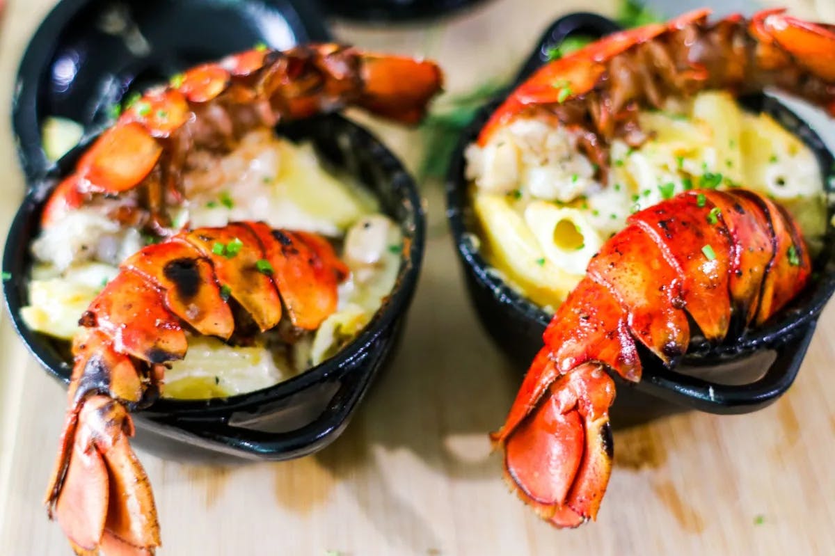 Cooked lobsters in black bowls.