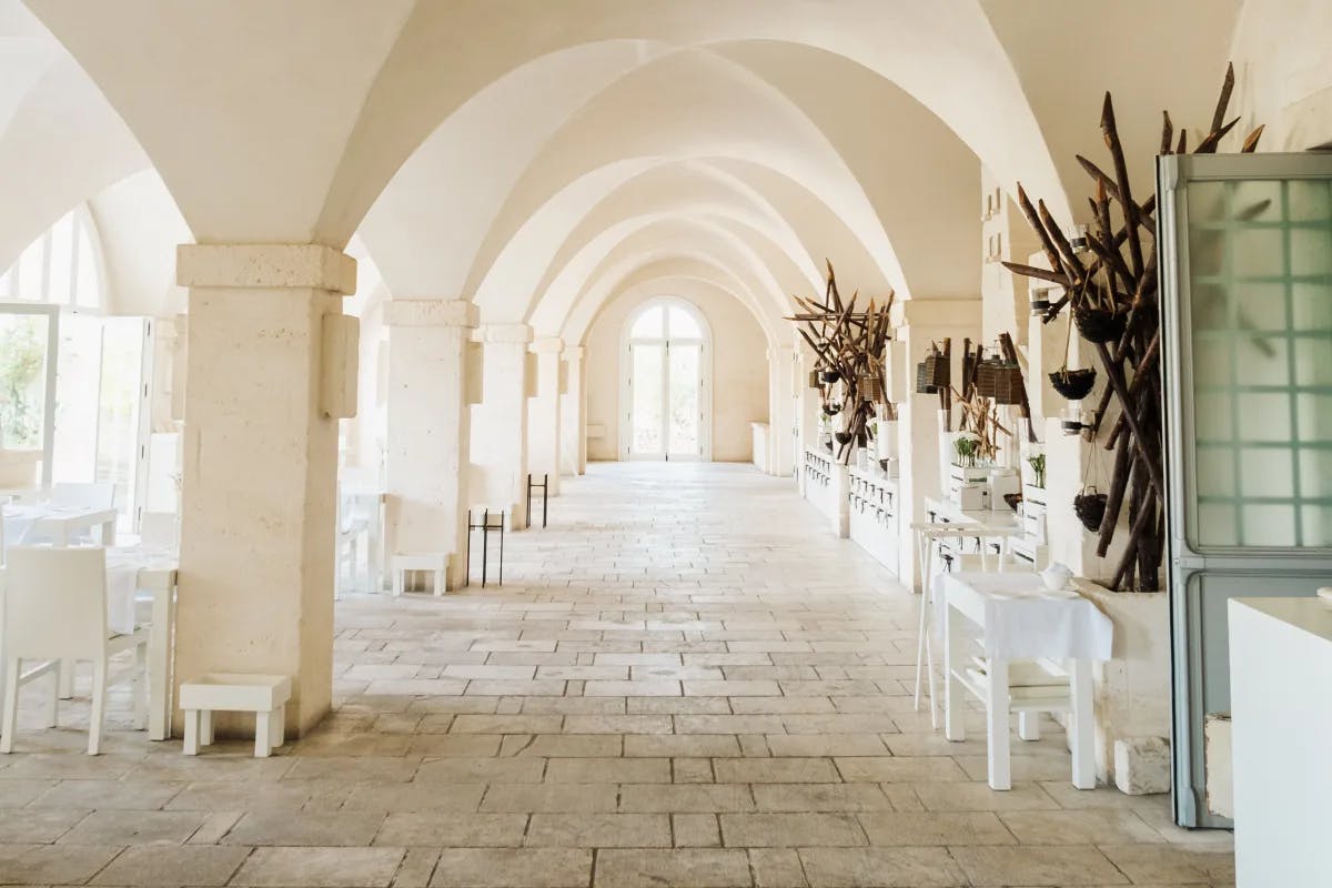 An arched hallway with white walls and tiled floor