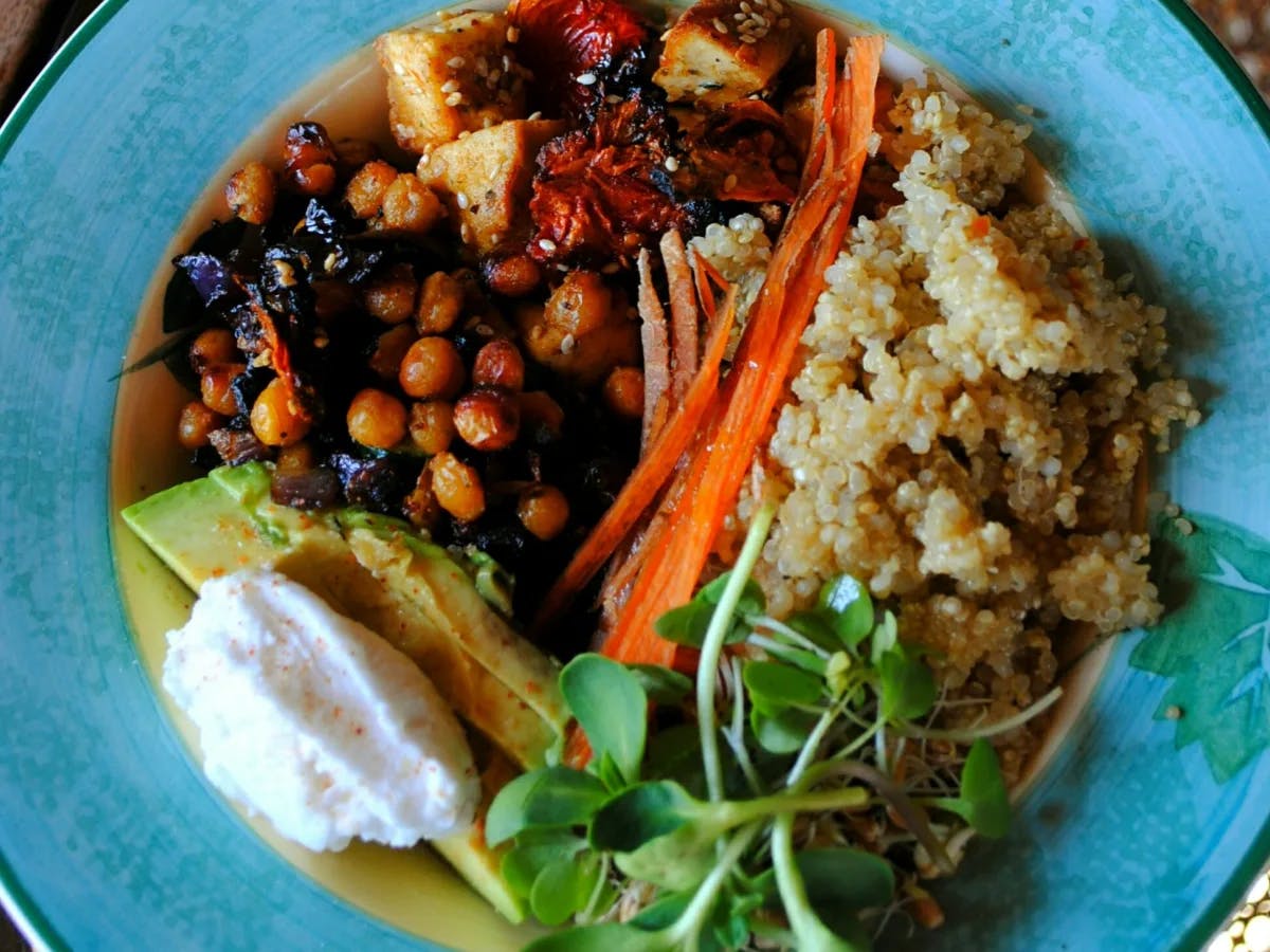 African food — chickpeas, rice, avocado – on a blue plate.