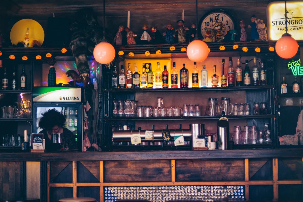 wooden bar with liquor bottles and orange floating flights