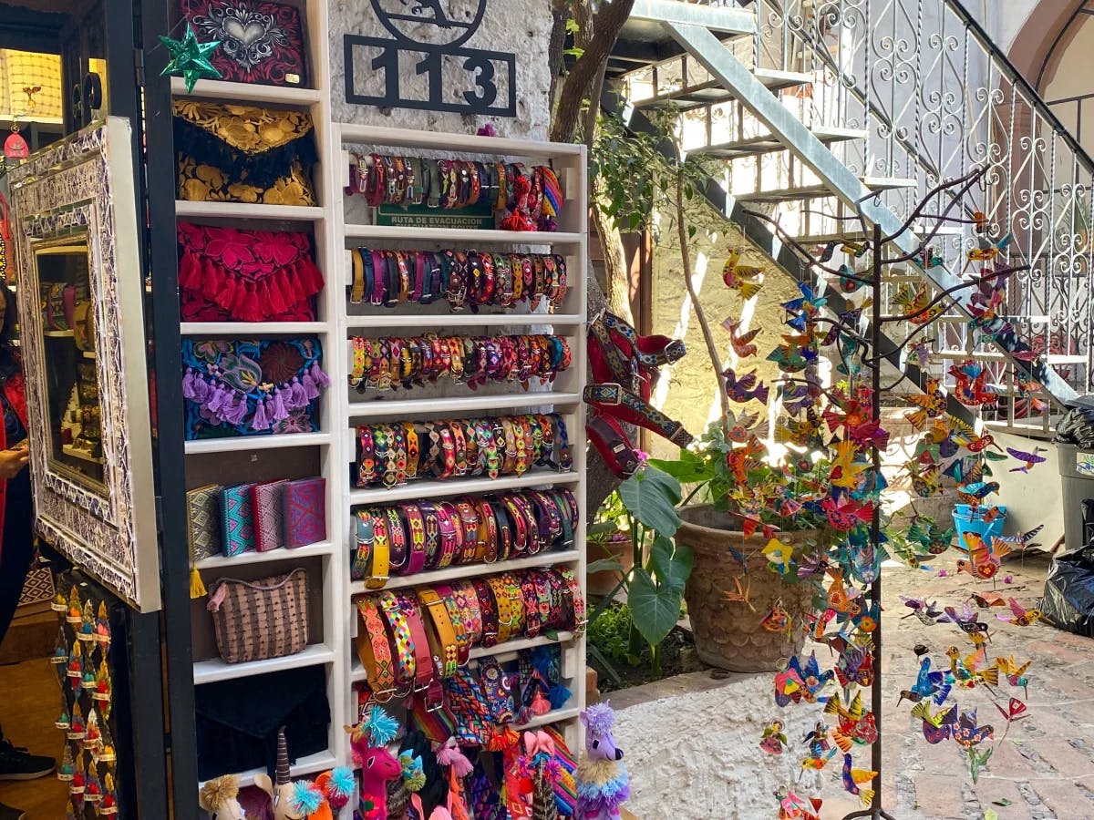 A boutique full of colorfully handmade souvenirs and a white staircase in the background.