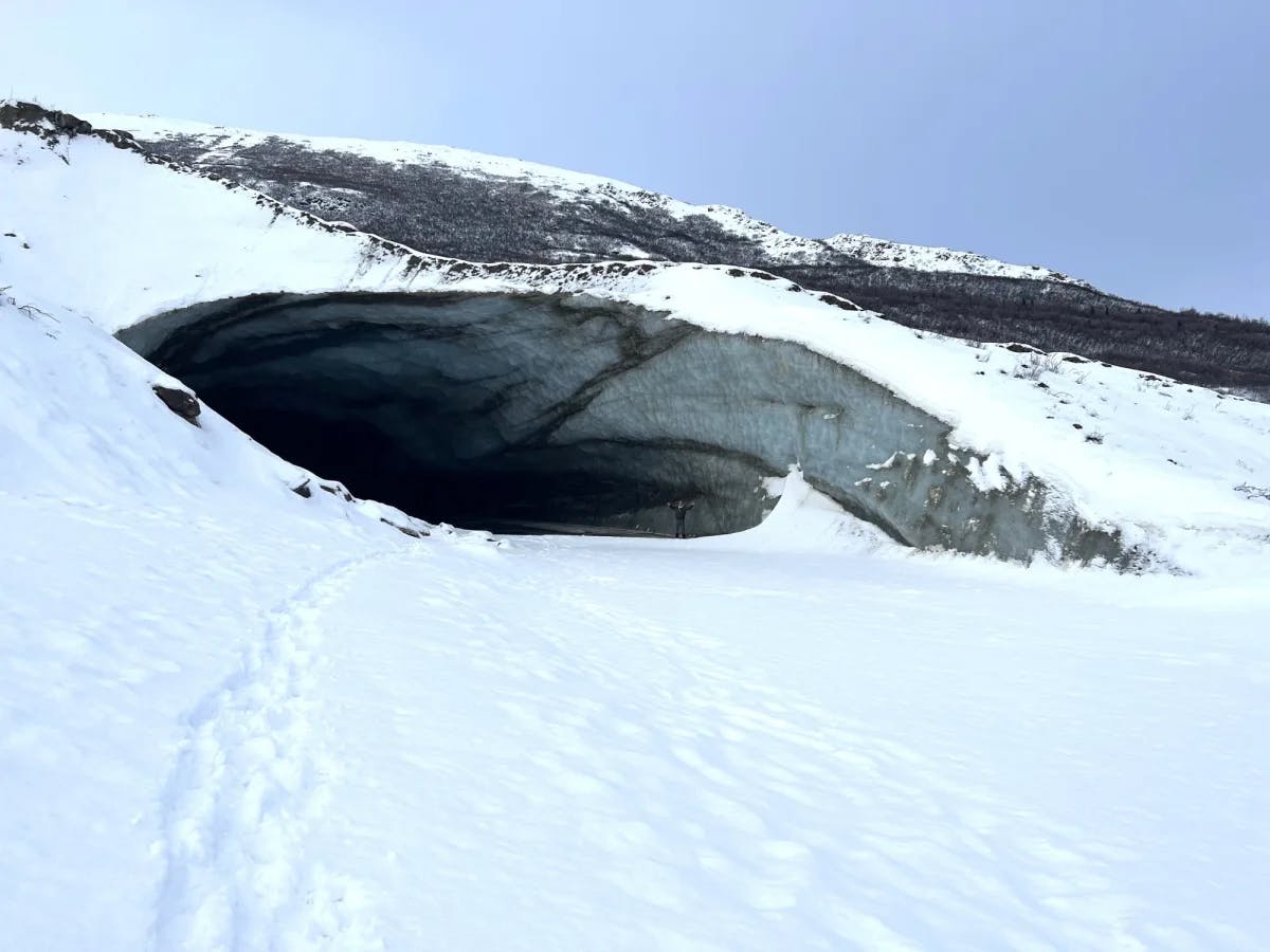 A cave surrounded by snow.