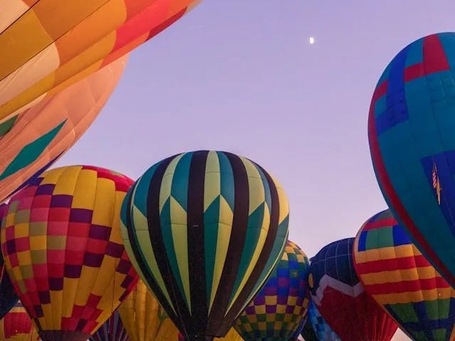 A group of hot air balloons during the sunrise