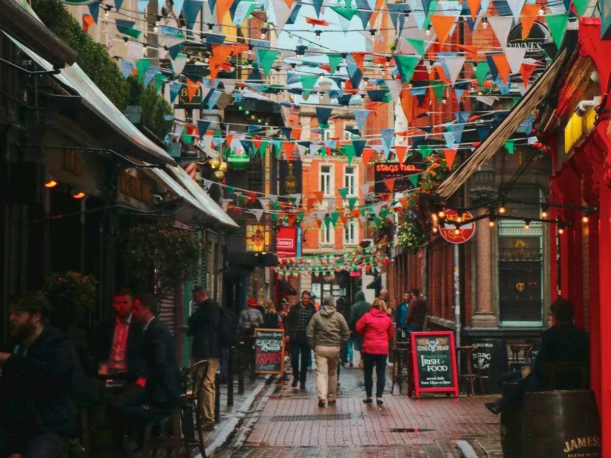 Street in Ireland with colorful flags hanging and restaurant with outdoor seating