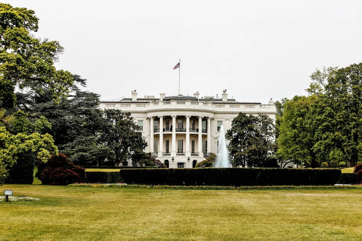 A far view of the White House surrounded by trees during the daytime.