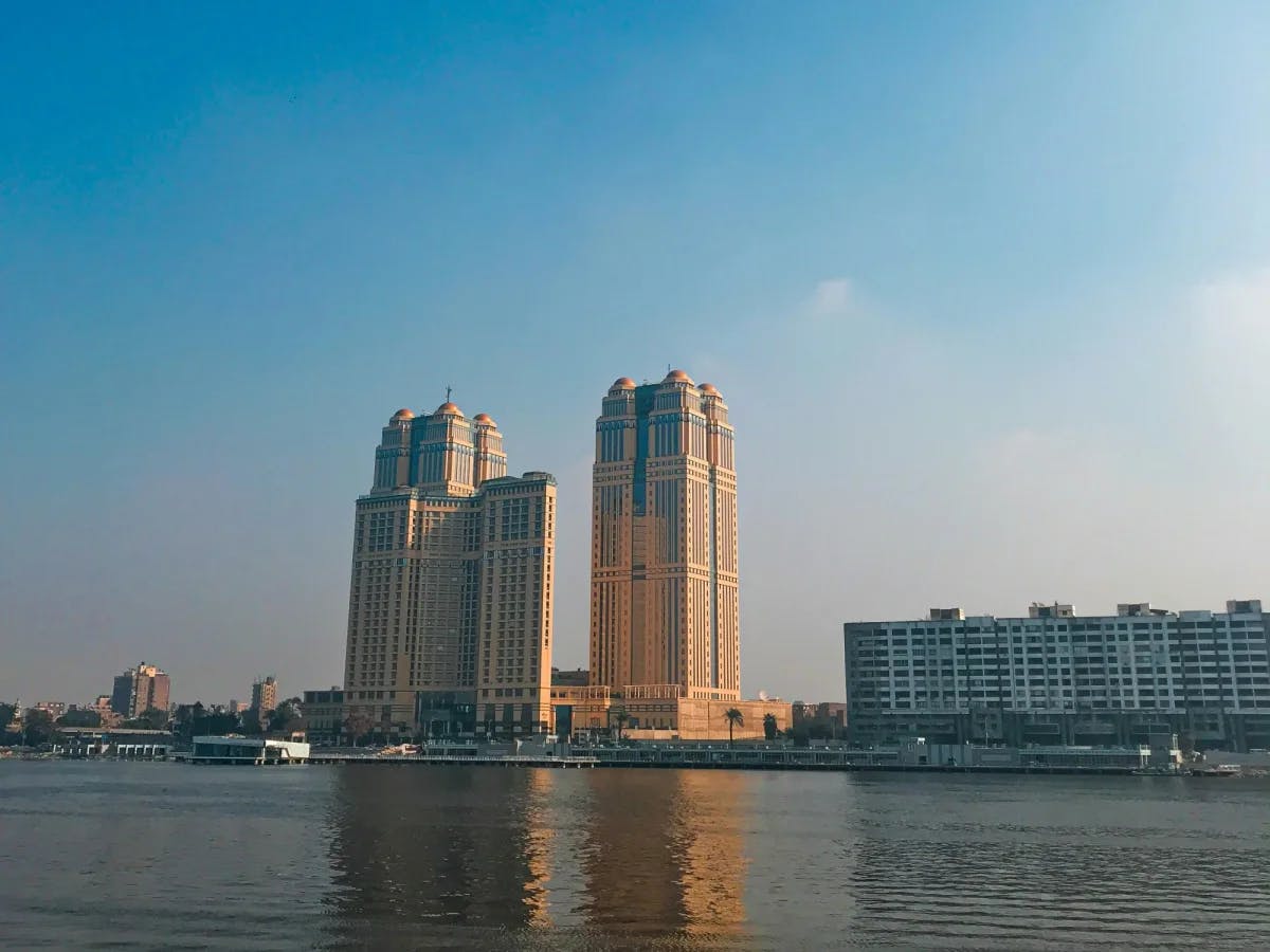 River with city buildings at the back on a sunny day.