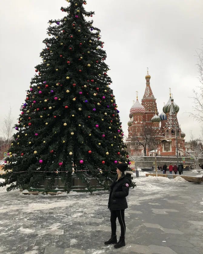 Travel advisor posing in front of Christmas tree 