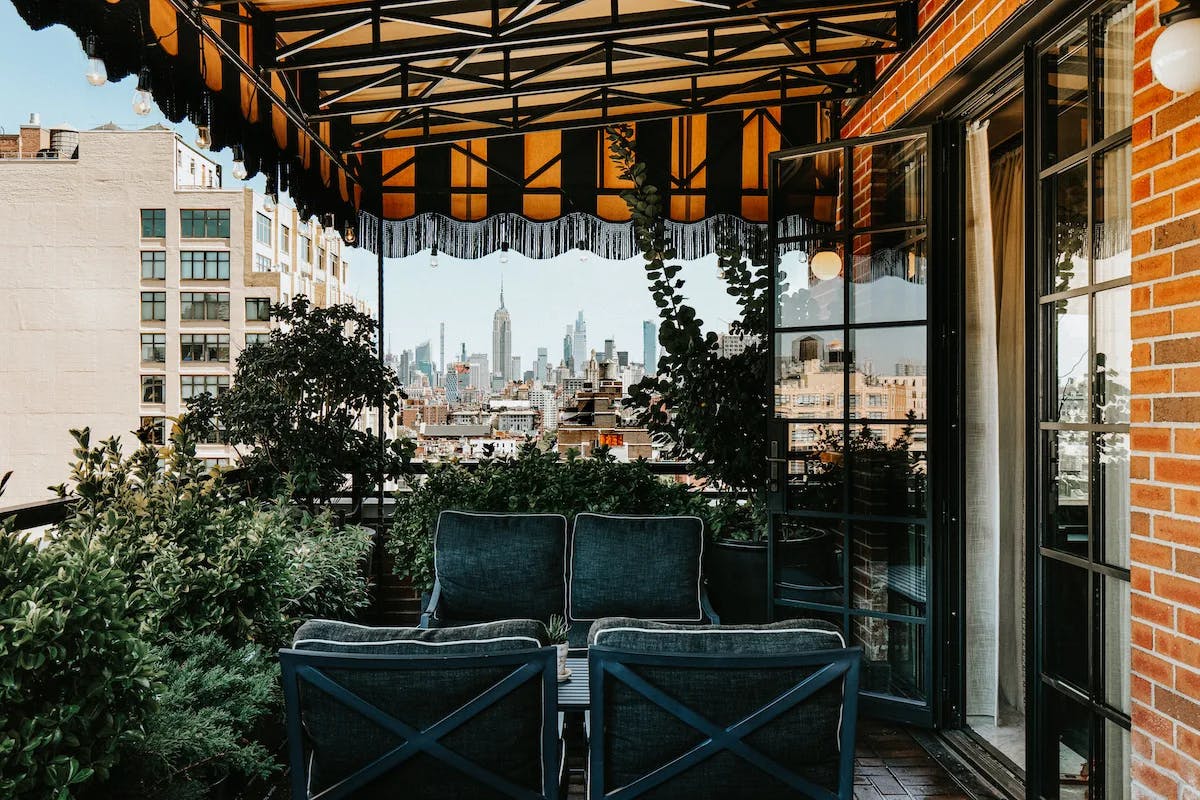 plush couches on an outdoor terrace overlooking a big city