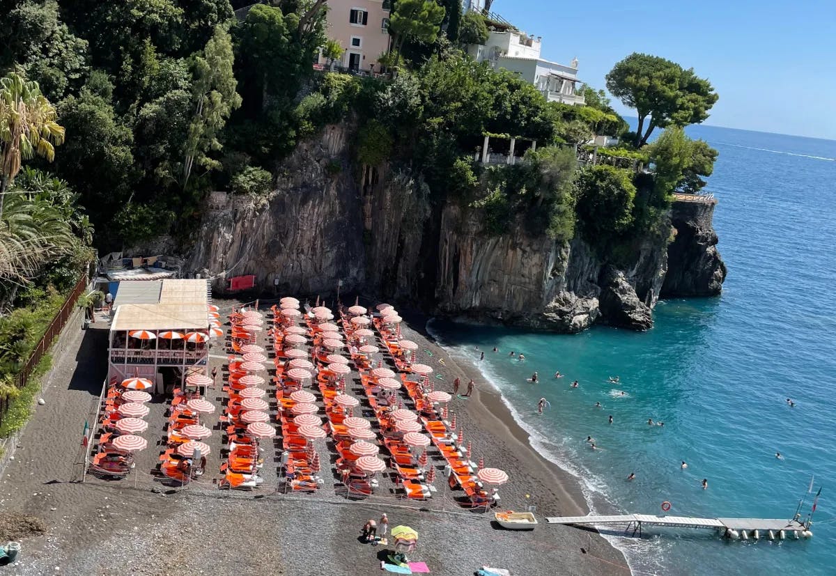 A beach club with umbrellas on a sea shore. 