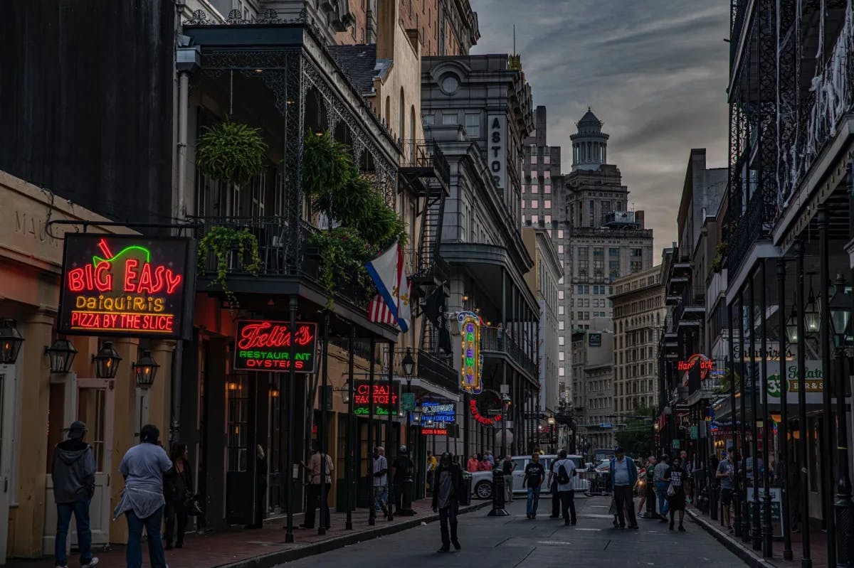 City street with buildings and people walking during evening. 