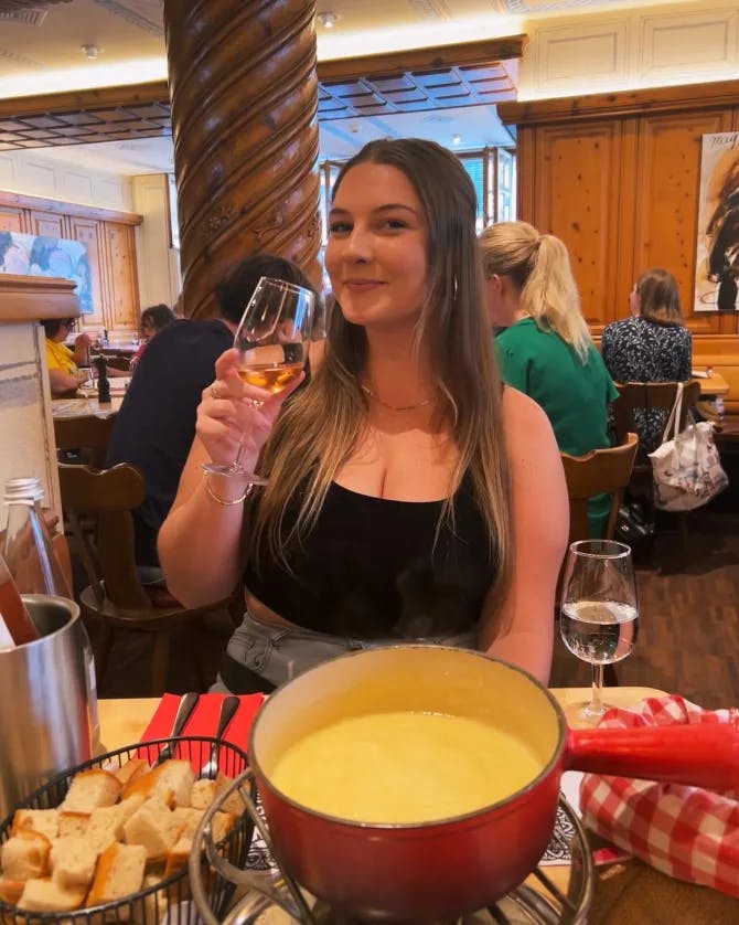 Advisor posing at restaurant with drink in hand.  