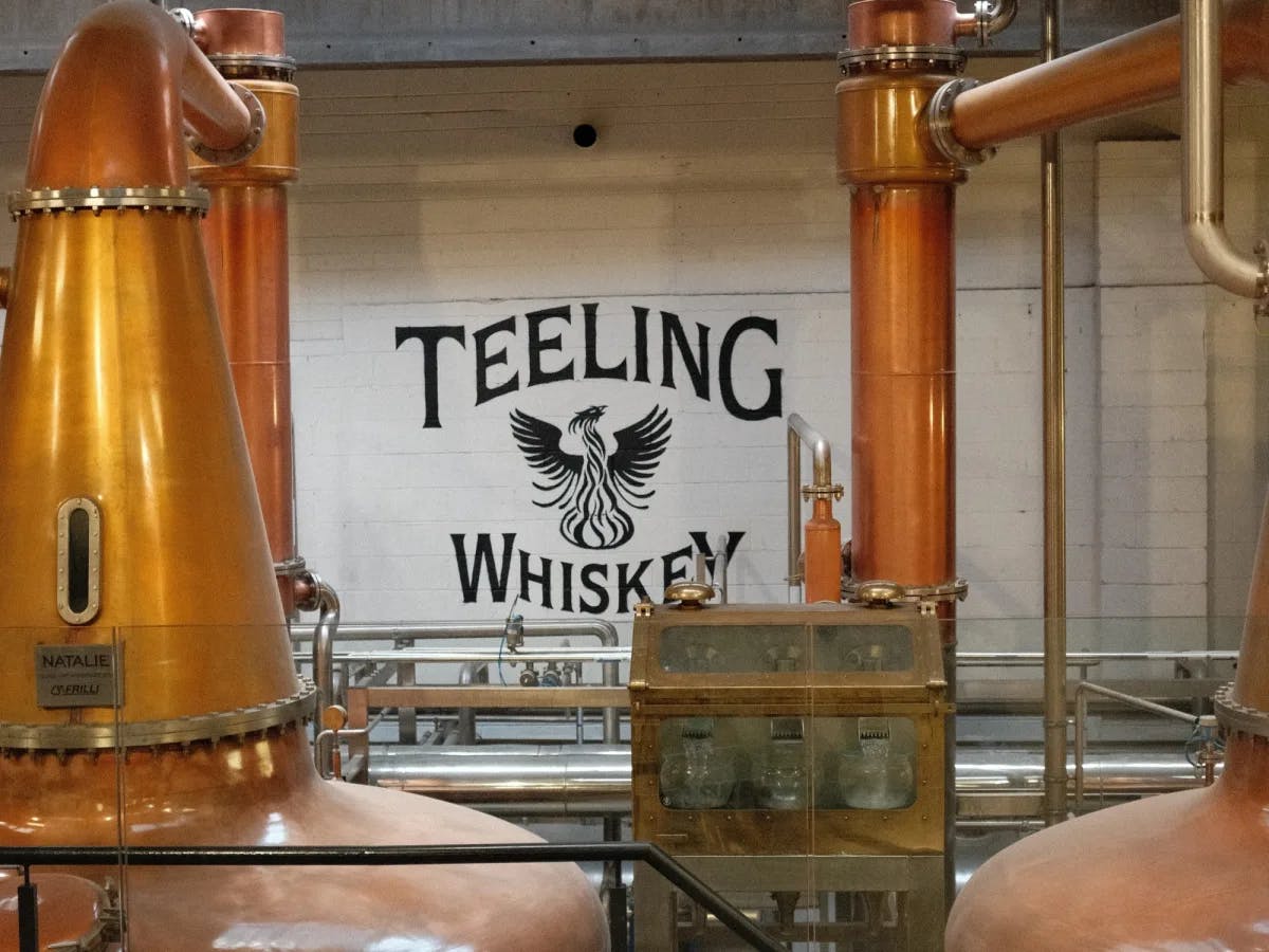 Distillery with Teelings Whiskey written on wall and large brass chambers.